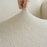Fingers lifting the stretchy sand linen jacquard fabric, highlighting its elastic textured surface