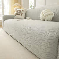 Angled close-up of soft ivory jacquard sofa cover showing wave texture and coffee cup
