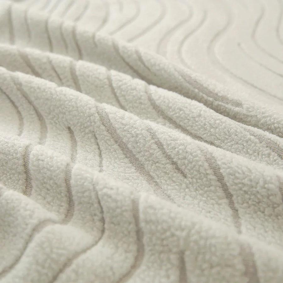 Macro of soft ivory jacquard fabric showing raised wave pattern and plush surface