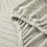 Detail of the elastic hem edge on the soft ivory jacquard stretch sofa cover
