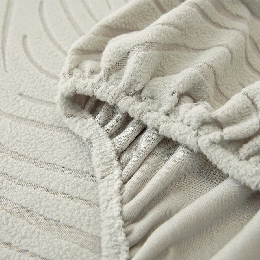Detail of the elastic hem edge on the soft ivory jacquard stretch sofa cover