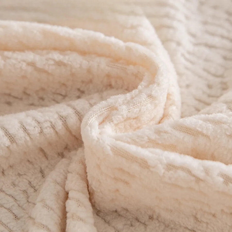 Macro of plush cream beige knit fabric showing fleece texture and fine striping