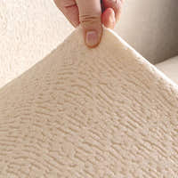 Detail of the cream beige knit fabric held up to reveal its soft fleece surface