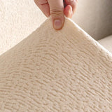 Detail of the cream beige knit fabric held up to reveal its soft fleece surface