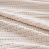 Macro of cream ivory knit fabric showing raised ribbed stripes and soft folds