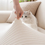 Hands stretching the cream ivory knit cover to show elasticity, with a fluffy cat nearby