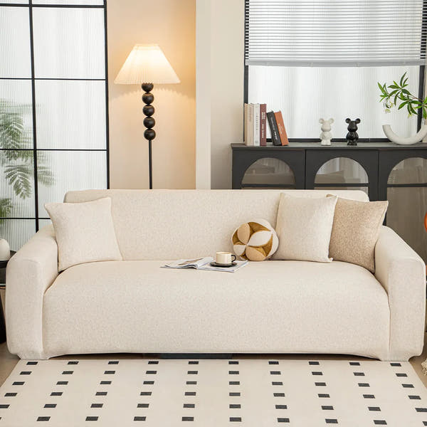 Cream linen knit sofa cover styled in a bright living room with floor lamp and patterned rug