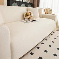 Close-up of cream linen knit sofa cover seat with decorative cushions and open magazine