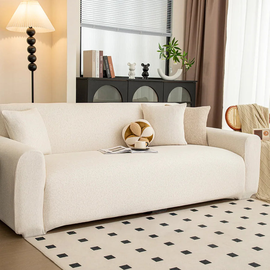 Angled view of cream linen knit sofa cover in a bright lounge with black cabinet and rug