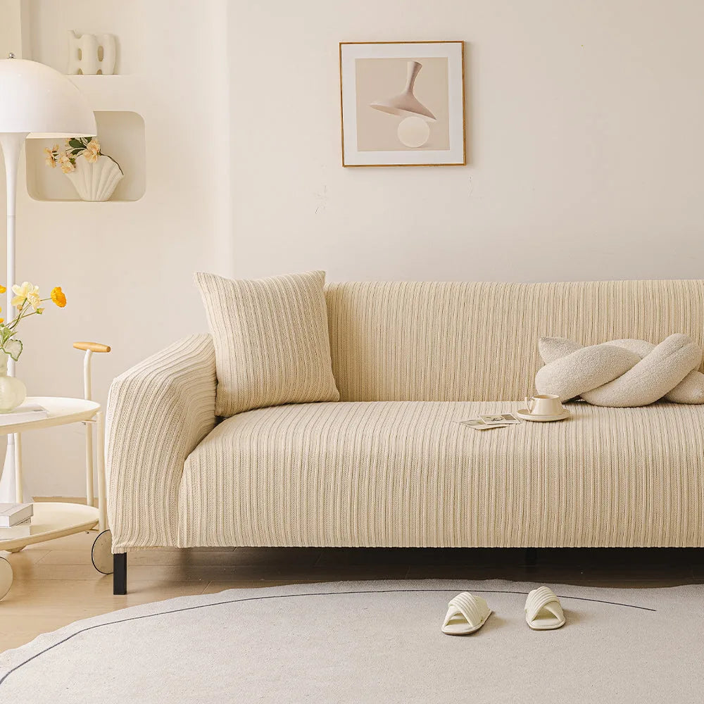 Honey taupe knit sofa cover in a bright living room with framed art and fresh flowers