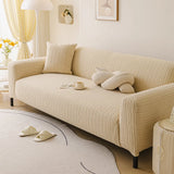 Honey taupe knit sofa cover styled in a sunlit lounge with knot cushion and round rug