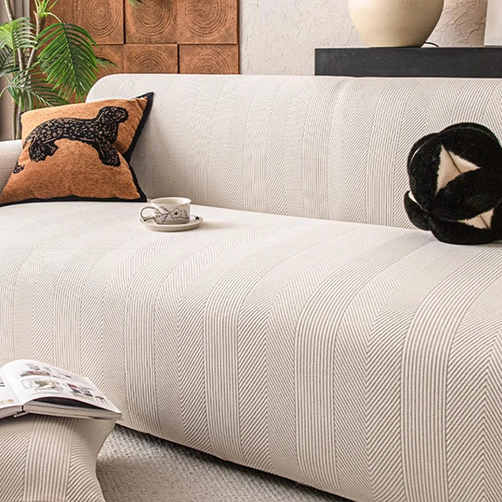 Ivory sand knit sofa cover draped over a sofa with herringbone texture and coffee cup