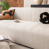 Ivory sand knit sofa cover draped over a sofa with herringbone texture and coffee cup