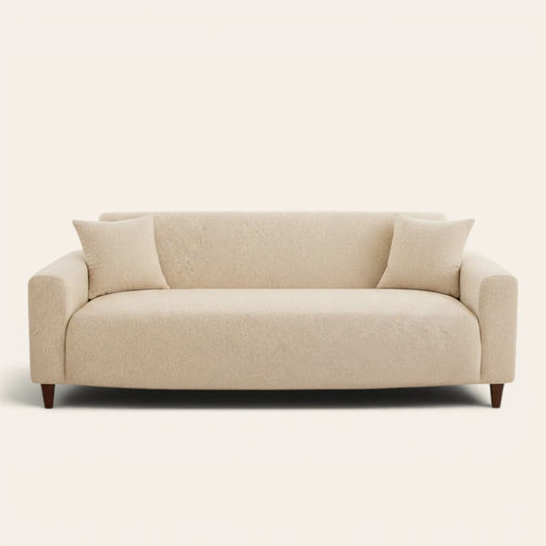 Sand beige knit sofa cover fitted on a three-seat couch with matching cushions, front view on ivory.