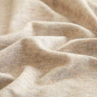 Macro of the sand beige knit texture with fine flecked striations draped in soft folds.