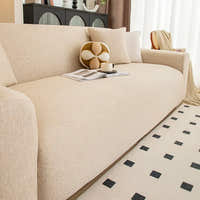 Angled living room view of the sand beige knit seat with a ball cushion, magazine and cup.
