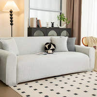Silver grey knit sofa cover styled in a bright living room with floor lamp and rug