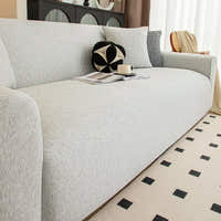 Close-up of silver grey knit sofa cover seat with decorative cushion and coffee cup