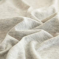Macro of soft silver grey knit fabric showing fine striped weave and gentle folds