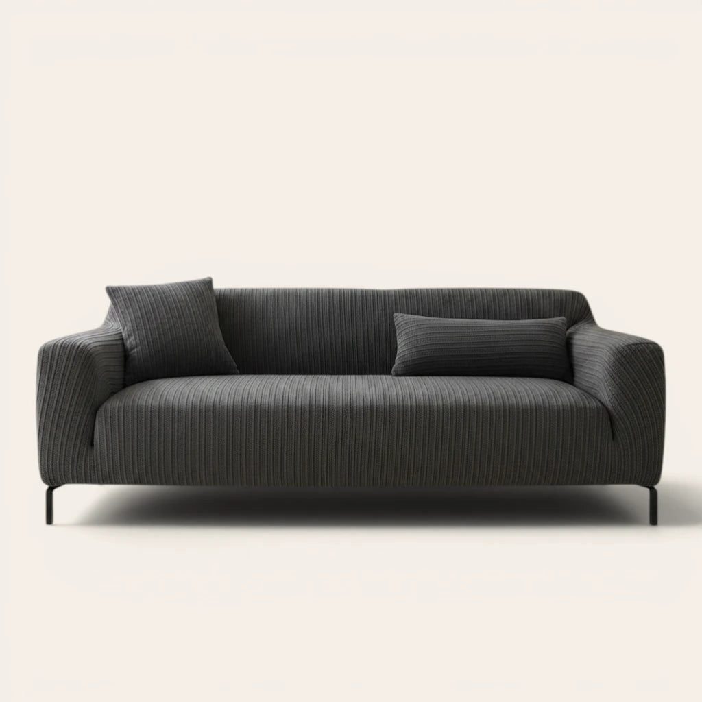 Slate charcoal ribbed knit sofa cover fitted on a three-seat couch with cushions, front view on ivory.