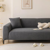 Sofa in slate charcoal ribbed knit cover, angled living room view with a knot cushion and framed art.