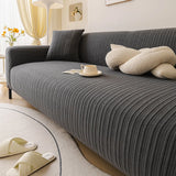 Close angled view of the slate charcoal ribbed knit seat with a knot cushion and coffee cup.