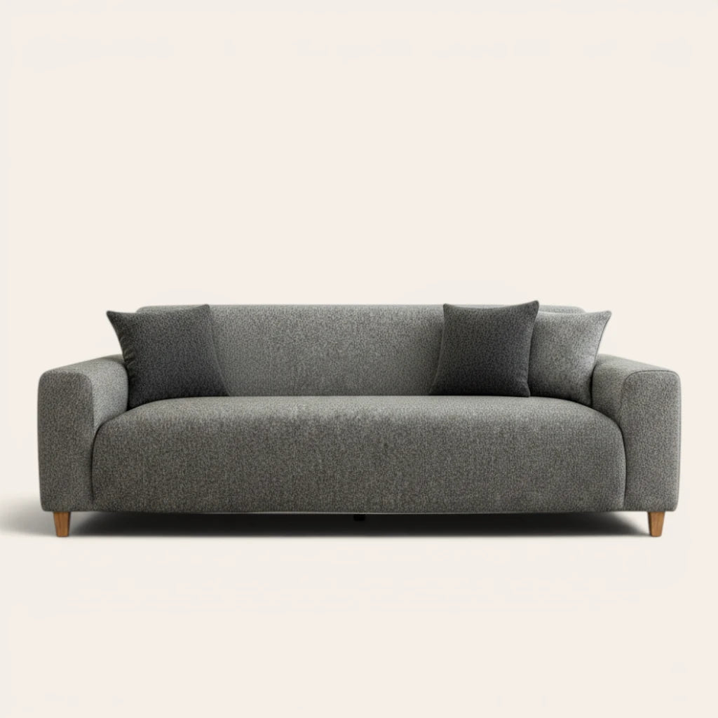 Stone grey knit sofa cover fitted on a three-seat couch with matching cushions, front view on ivory.