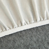 Detail of the elasticated hem and white band beneath the stone grey knit cover.