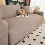 Angled close view of the warm taupe knit seat styled with a book, cup and ball cushion.