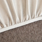 Detail of the elasticated hem and white band beneath the warm taupe knit cover.