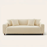 Cream ivory quilted sofa cover fitted on a three-seat couch with matching cushions, front view on ivory.