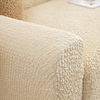 Close-up of the seam and armrest on the cream ivory quilted sofa cover.