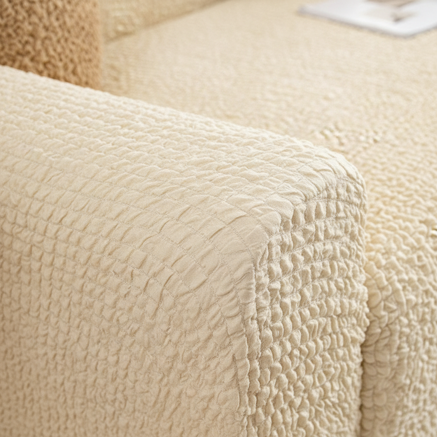 Close-up of the seam and armrest on the cream ivory quilted sofa cover.
