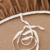 Detail of the elasticated hem and white tie fasteners beneath the caramel sand cover.