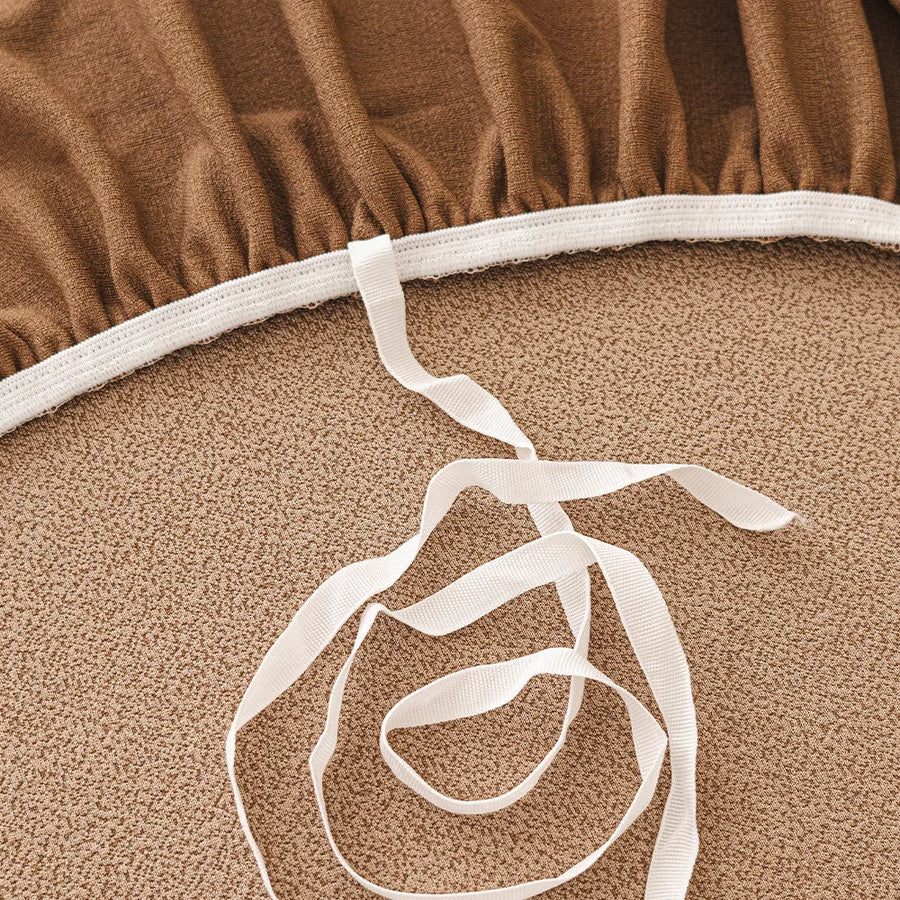 Detail of the elasticated hem and white tie fasteners beneath the caramel sand cover.