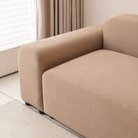 Caramel sand smooth cover wrapping a sofa armrest and seat beside a bright window.