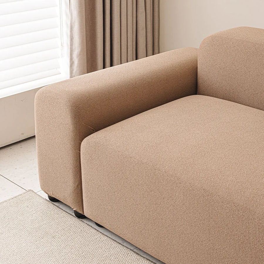 Caramel sand smooth cover wrapping a sofa armrest and seat beside a bright window.