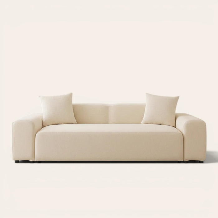 Cream smooth sofa cover on a three-seat sofa with matching cushions, front view on ivory