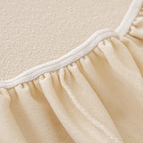 Close-up of the cream sofa cover elastic hem with ivory binding detail