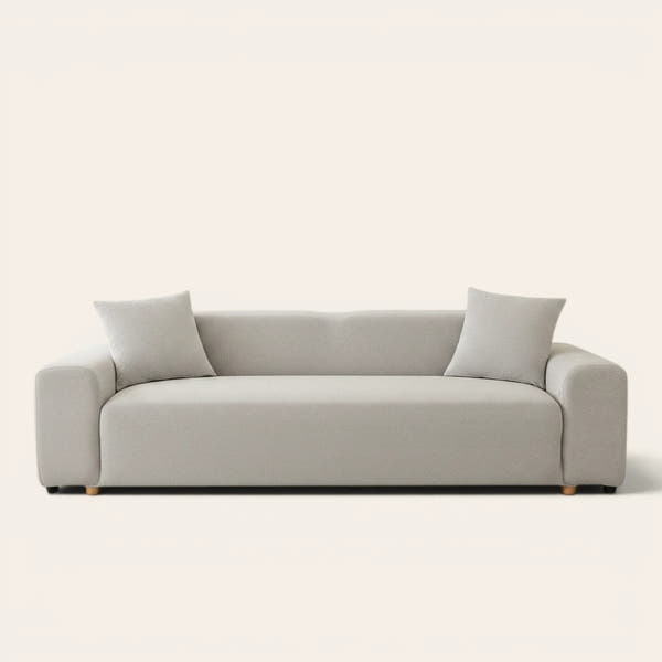 Silver grey smooth sofa cover on a three-seat sofa with matching cushions, front view on ivory