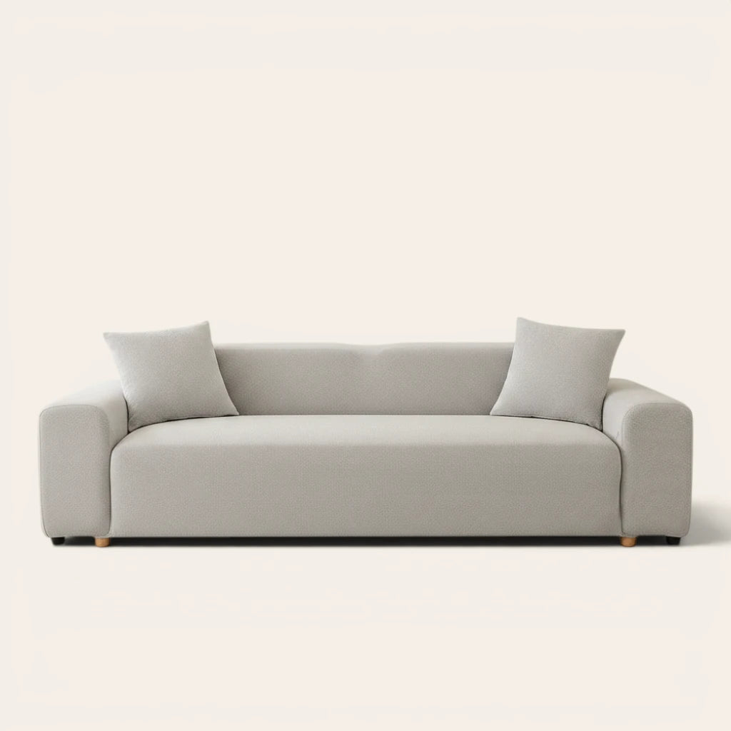 Silver grey smooth sofa cover on a three-seat sofa with matching cushions, front view on ivory