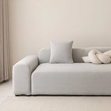 Silver grey smooth stretch sofa cover styled on a corner sofa with a cushion and knot pillow
