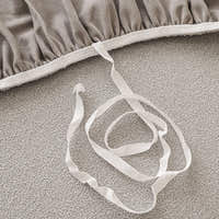 Underside detail of the silver grey sofa cover elastic hem and white tuck strap