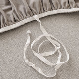 Underside detail of the silver grey sofa cover elastic hem and white tuck strap