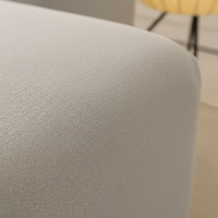 Close-up of the silver grey sofa cover curving over the rounded armrest