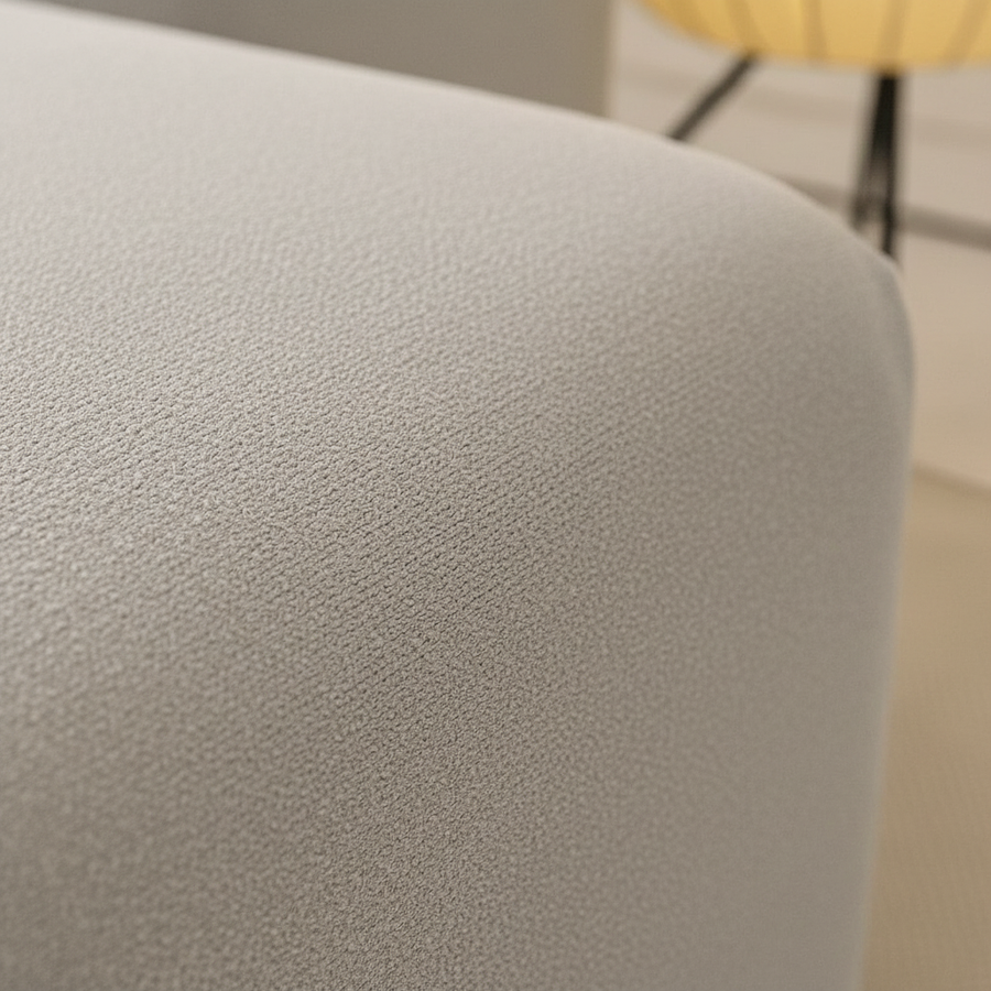 Close-up of the silver grey sofa cover curving over the rounded armrest