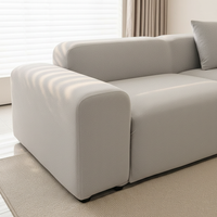 Silver grey smooth sofa cover wrapping the armrest and seat corner on a woven rug