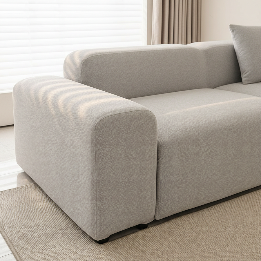 Silver grey smooth sofa cover wrapping the armrest and seat corner on a woven rug