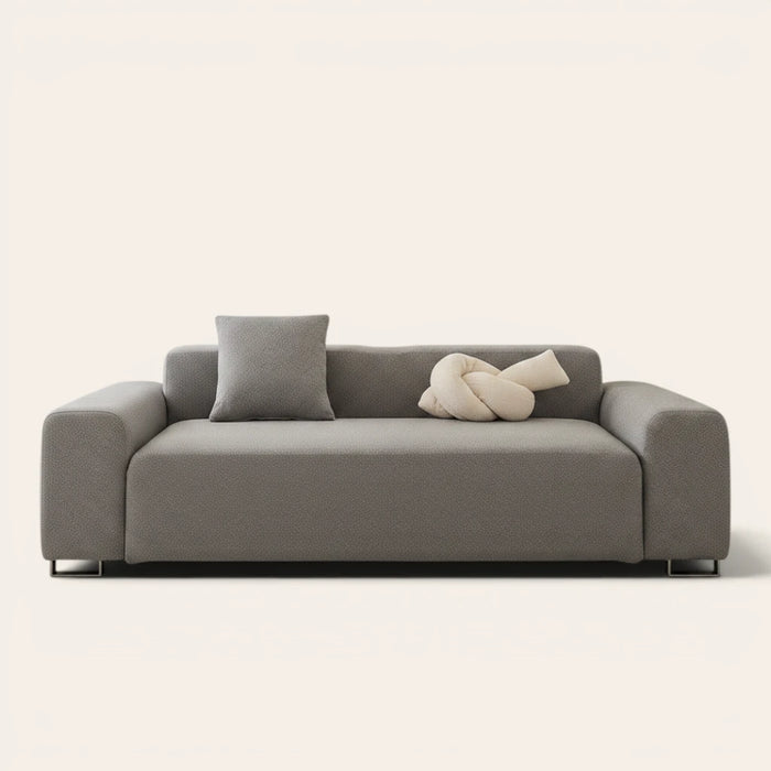 Stone grey smooth sofa cover fitted on a three-seat sofa with matching cushions, front view on ivory