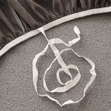 Underside detail of the stone grey sofa cover elastic hem and white tuck strap